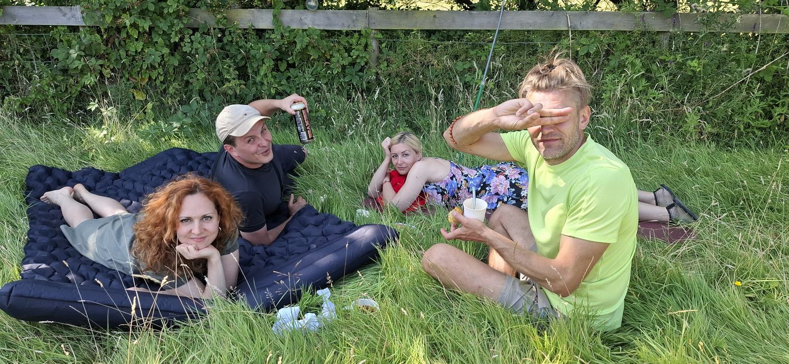 Friends relaxing on blankets on the grass at the picnic